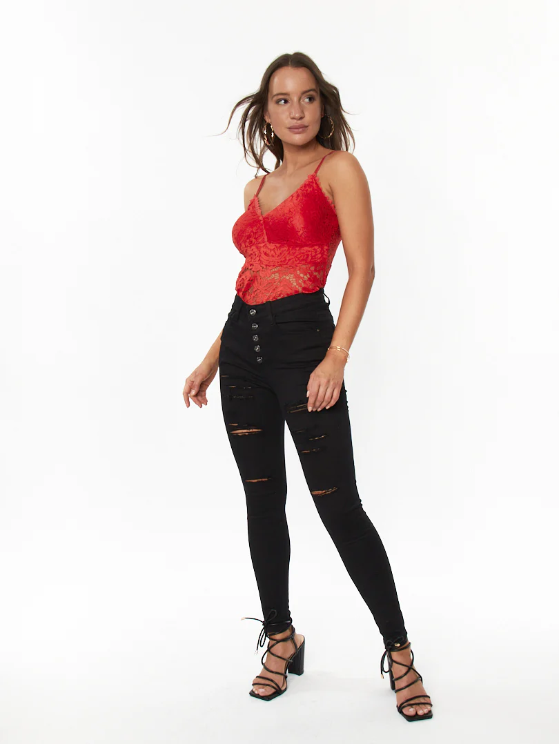 Jean skinny noir à boutons et déchirures légères